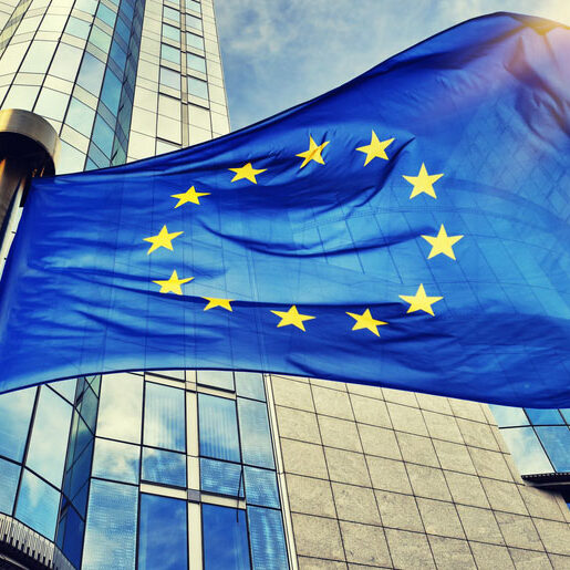 EU flag waving in front of European Parliament building. Brussels, Belgium